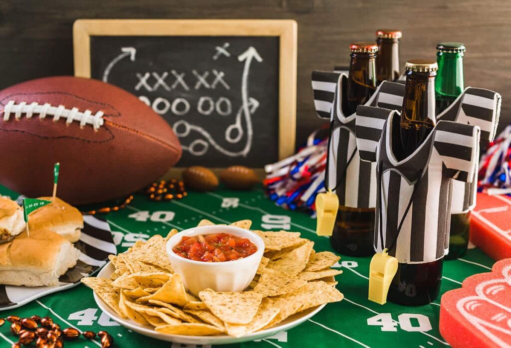 game day chips salsa football and adult beverages on a table