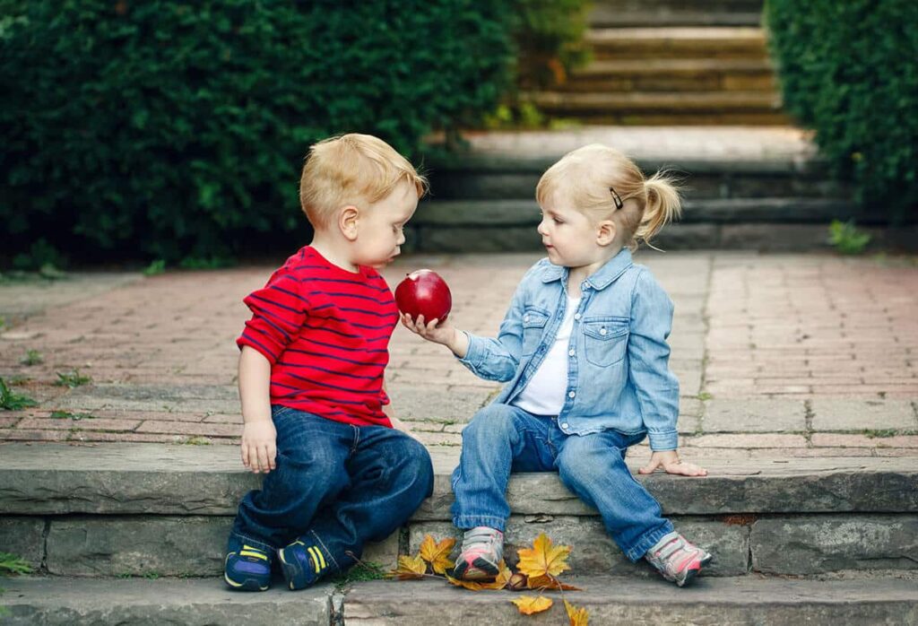 two kids sharing an apple