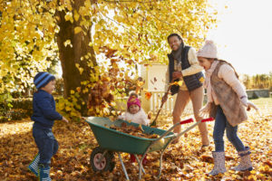 family raking leaves