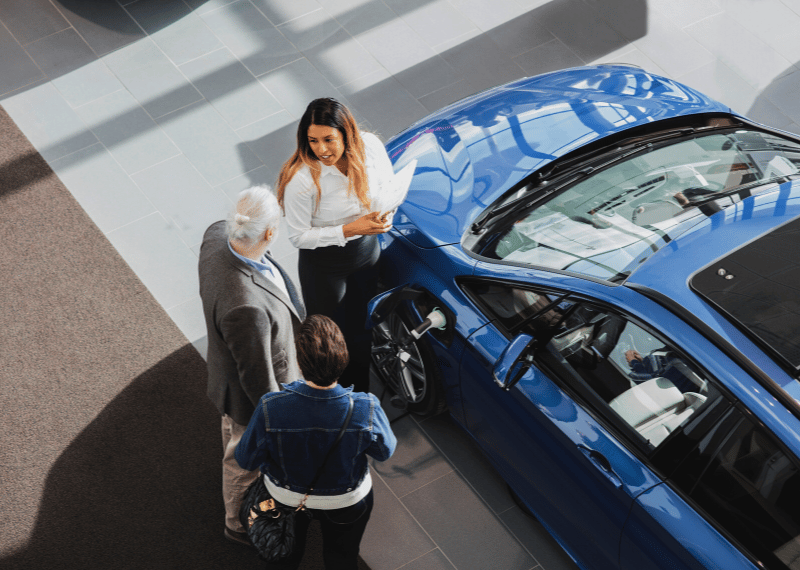 saleswoman discussing car loan options with customers